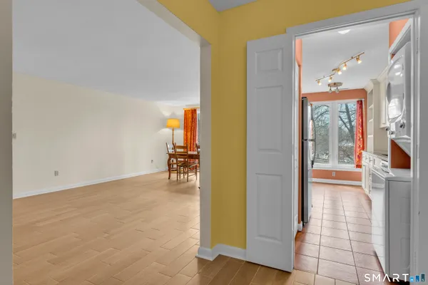 a view of a hallway with wooden floor and a living room
