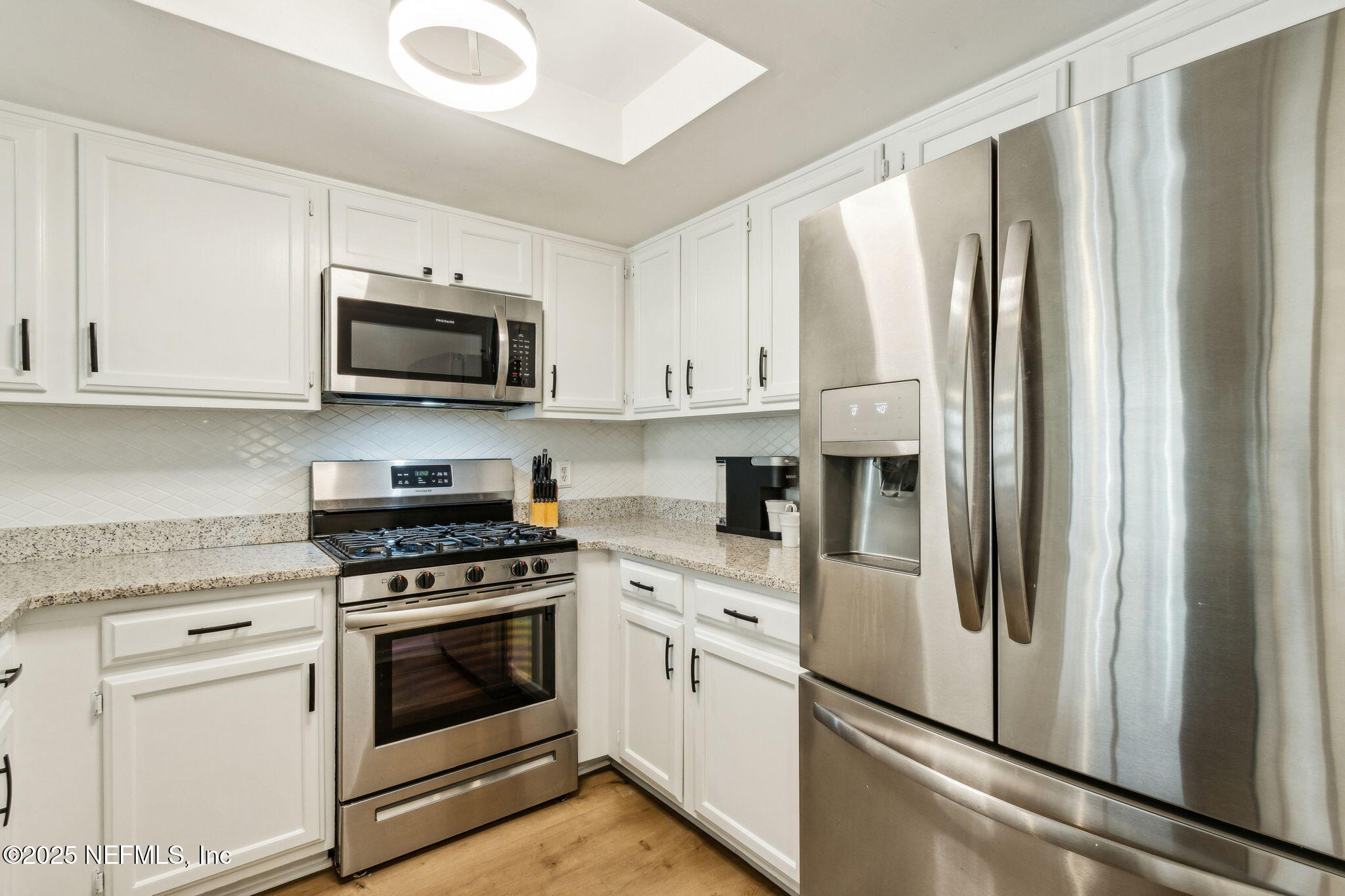 2751 West 5th Street, Unit B Fernandina Beach, FL 32034 - Photo 20 of 61 a kitchen with stainless steel appliances white cabinets white stove a microwave and a refrigerator