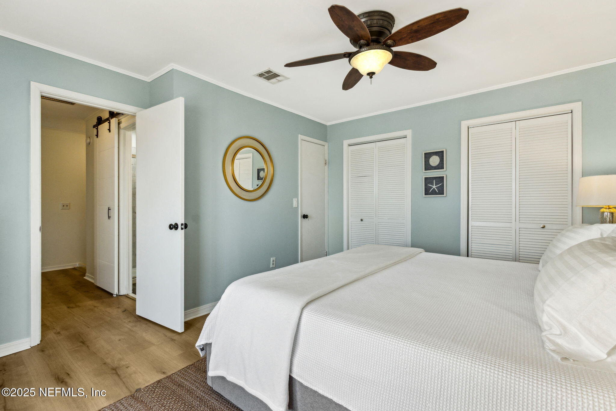 2751 West 5th Street, Unit B Fernandina Beach, FL 32034 - Photo 32 of 61 a bedroom with a bed and a chandelier