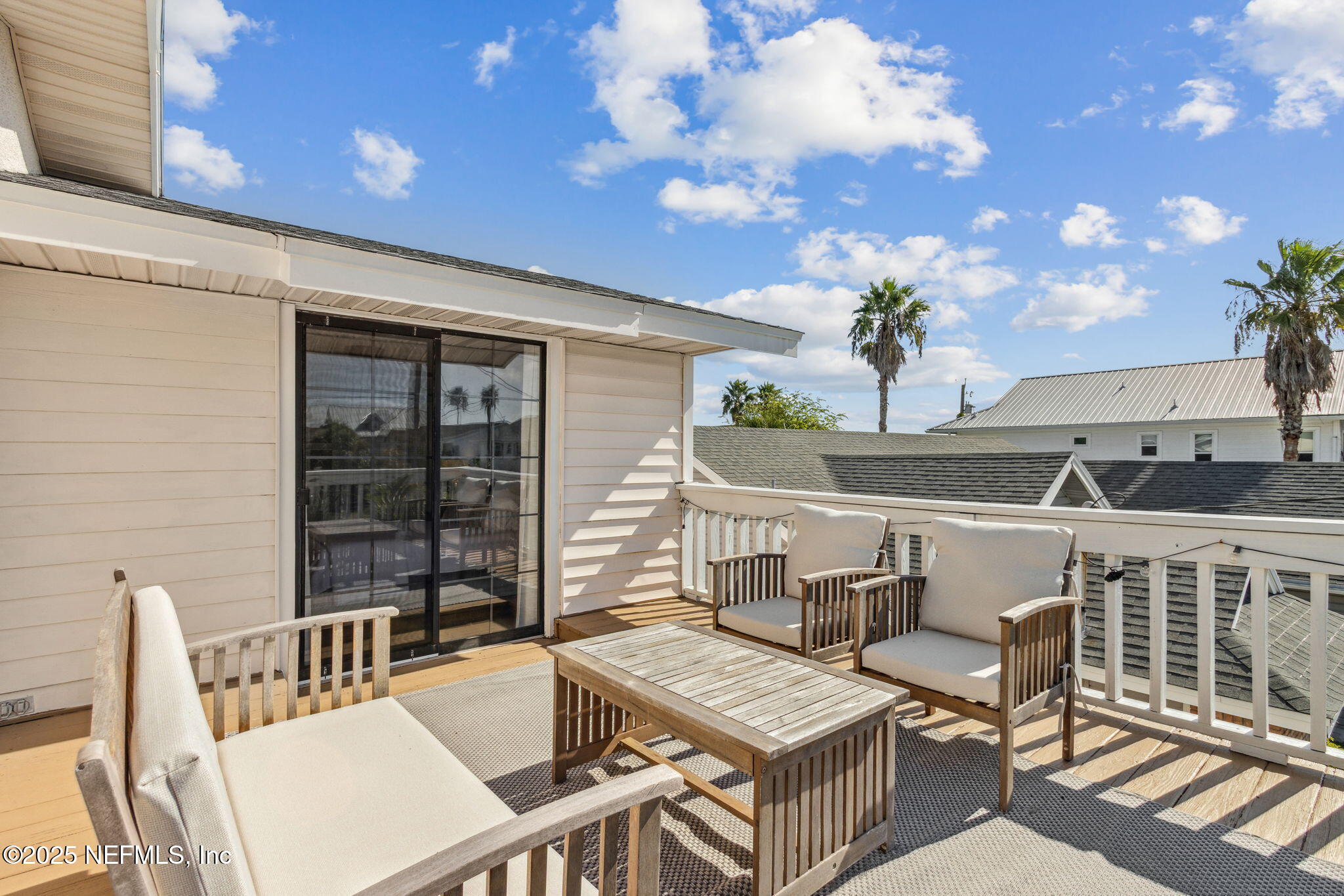 2751 West 5th Street, Unit B Fernandina Beach, FL 32034 - Photo 47 of 61 a roof deck with a dining table and chairs with wooden floor
