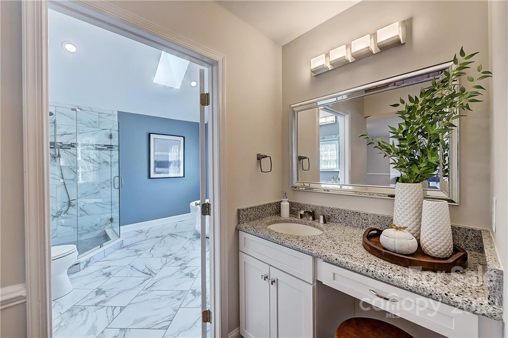 4222 Kronos Place Charlotte, NC 28210 - Photo 32 of 46 a bathroom with a granite countertop sink a mirror and vanity