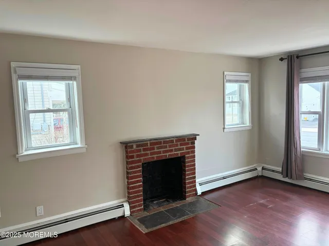 an empty room with windows and fireplace