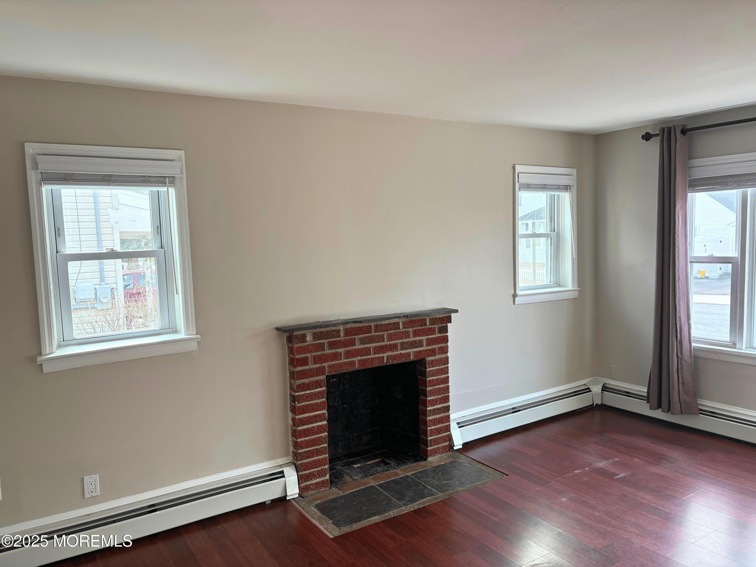 33 Prospect Avenue, Unit C Red Bank, NJ 07701 - Photo 4 of 15 an empty room with windows and fireplace
