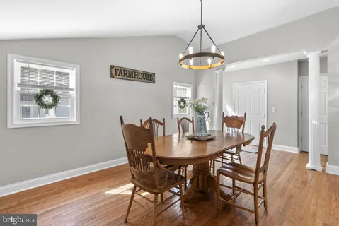 a dining room with furniture a chandelier and wooden floor