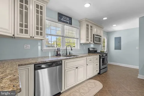 a kitchen with stainless steel appliances granite countertop a sink stove and cabinets