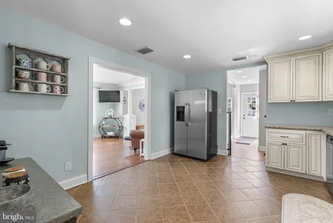 a view of a kitchen with refrigerator and windows