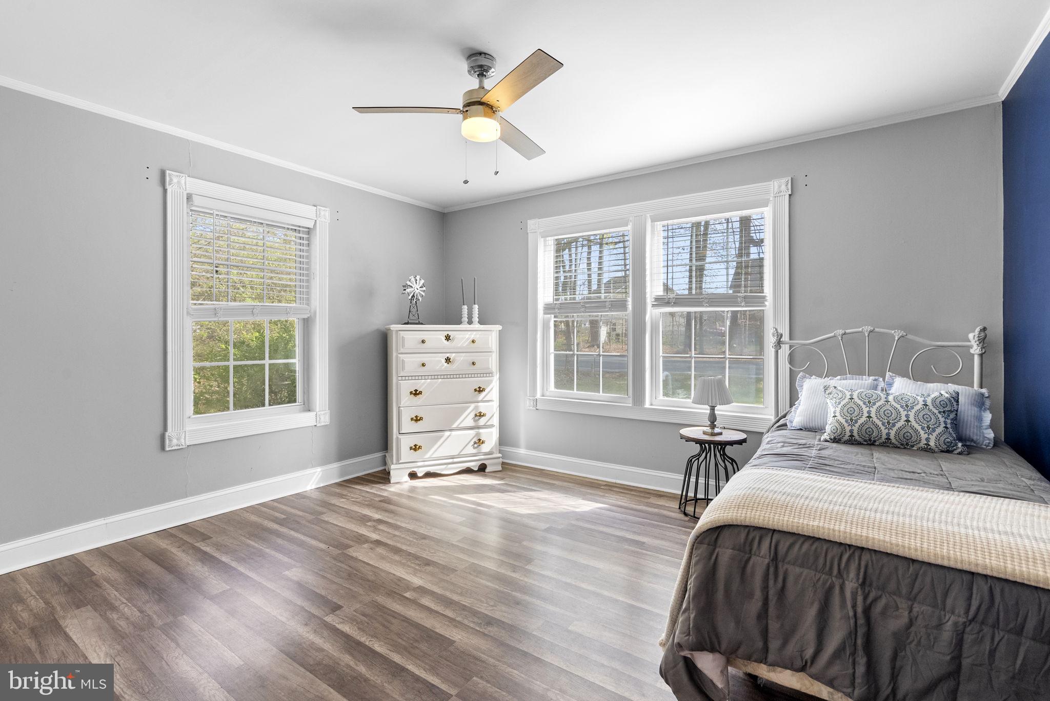 604 Perrys Corner Road Grasonville, MD 21638 - Photo 18 of 32 a spacious bedroom with a bed a dresser and windows
