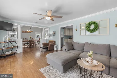 a living room with furniture a wooden floor and a chandelier