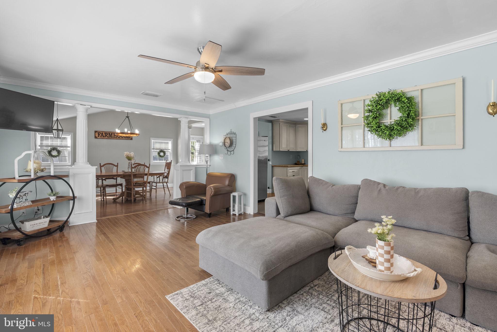 604 Perrys Corner Road Grasonville, MD 21638 - Photo 6 of 32 a living room with furniture a wooden floor and a chandelier