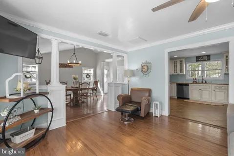 a living room with furniture and a dining table with kitchen view
