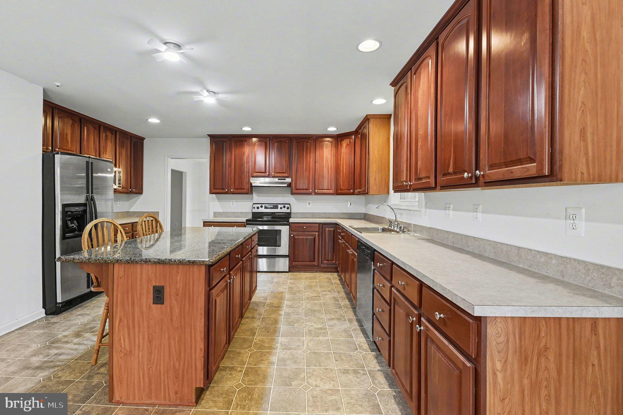 1645 Timber Summit Drive Westminster, MD 21157 - Photo 17 of 65 a kitchen with kitchen island granite countertop wooden cabinets a sink and dishwasher