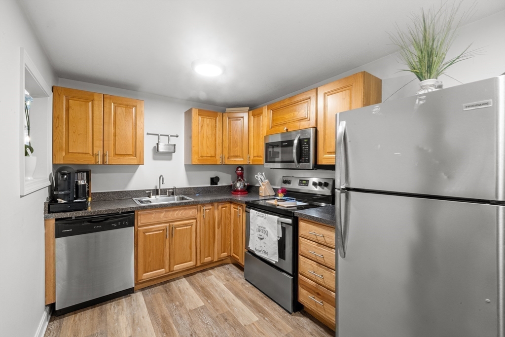 1619 Braley Road, Unit 97 New Bedford, MA 02745 - Photo 13 of 27 a kitchen with a refrigerator a sink and cabinets