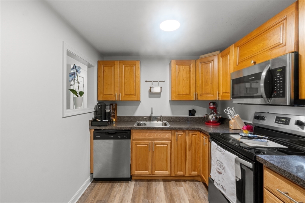 1619 Braley Road, Unit 97 New Bedford, MA 02745 - Photo 14 of 27 a kitchen with stainless steel appliances granite countertop a stove a sink and a microwave