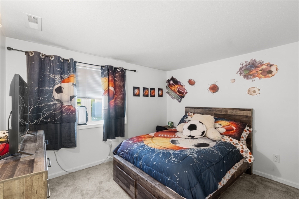 1619 Braley Road, Unit 97 New Bedford, MA 02745 - Photo 18 of 27 a bedroom with a bed and a white kitchen