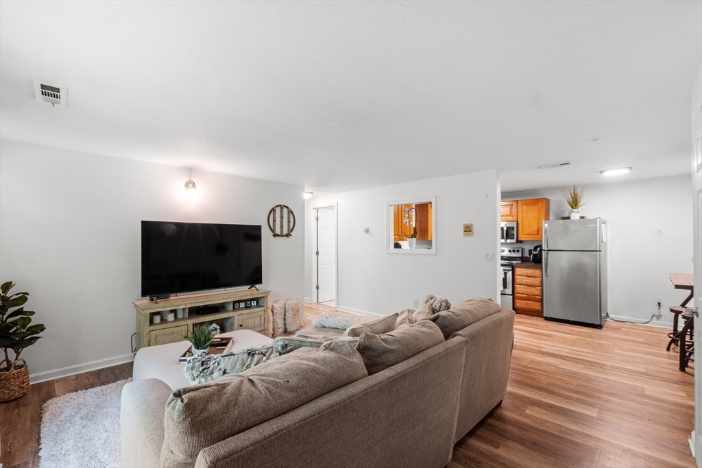 1619 Braley Road, Unit 97 New Bedford, MA 02745 - Photo 4 of 27 a living room with furniture and a flat screen tv
