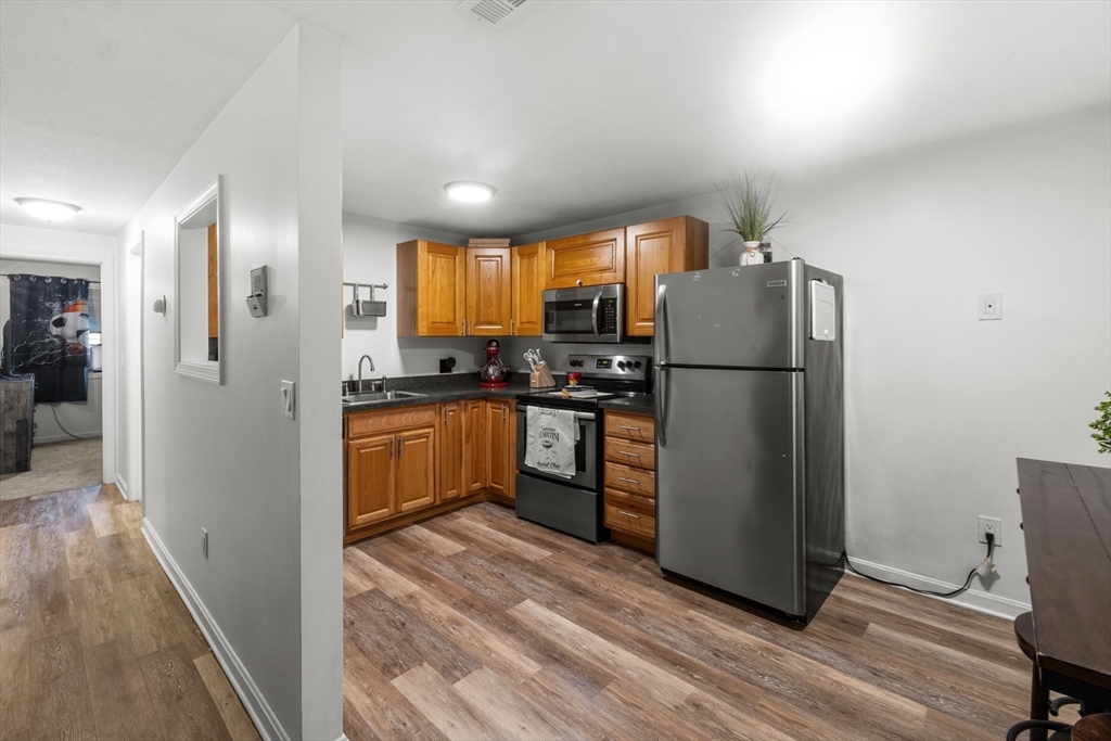 1619 Braley Road, Unit 97 New Bedford, MA 02745 - Photo 9 of 27 a kitchen with a refrigerator and a stove top oven