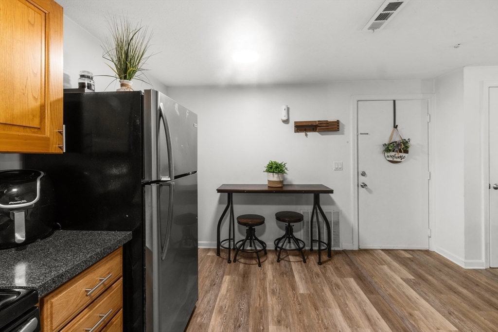 1619 Braley Road, Unit 97 New Bedford, MA 02745 - Photo 10 of 27 a kitchen with a refrigerator and a wooden cabinets