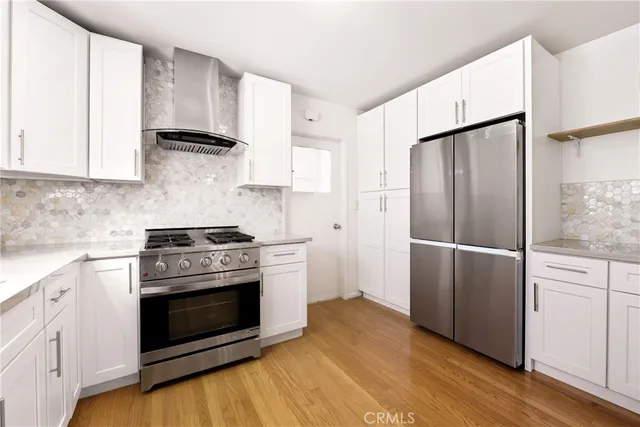 a kitchen with stainless steel appliances wooden floor sink and stove