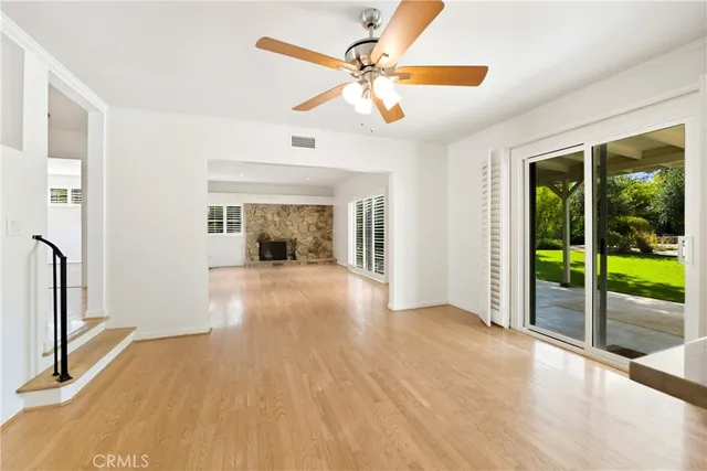 a view of a livingroom with wooden floor and a ceiling fan
