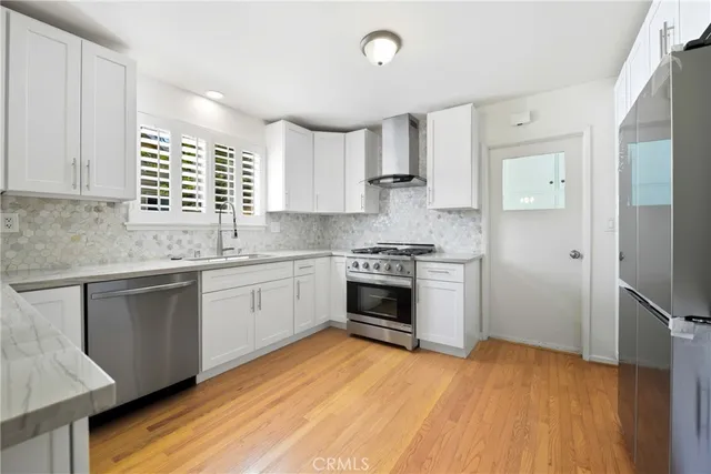 a kitchen with stainless steel appliances a stove a sink and a refrigerator