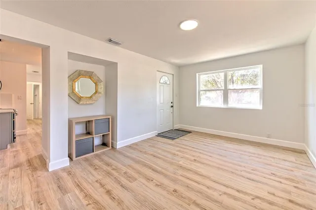 an empty room with windows and wooden floor
