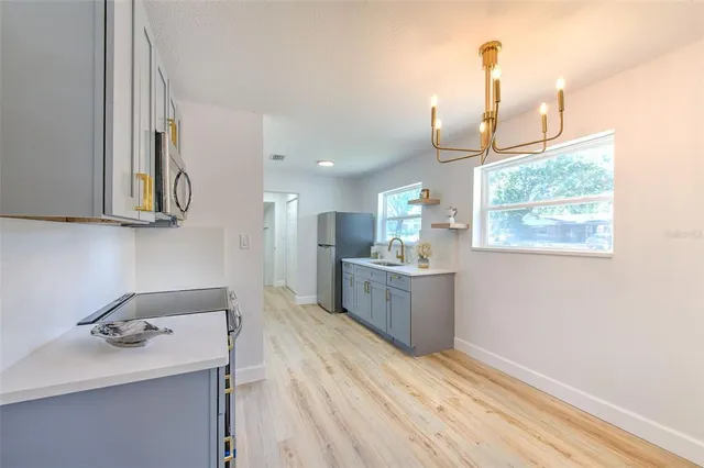 a kitchen with a sink cabinets and wooden floor