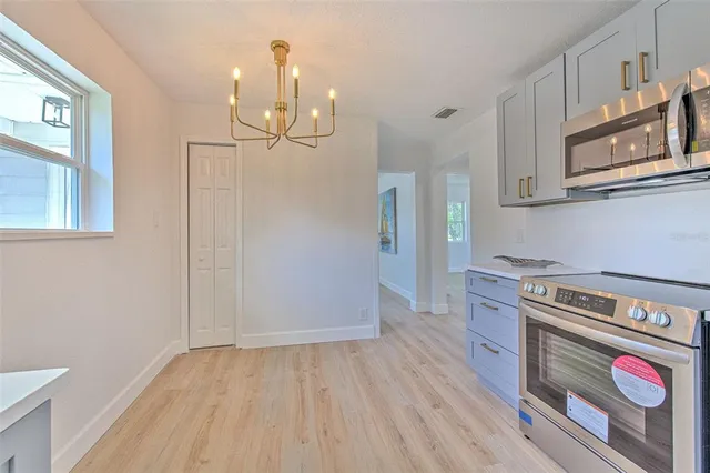 a kitchen with stainless steel appliances granite countertop a dishwasher a stove and a wooden floors