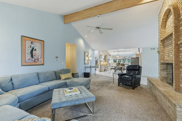 a living room with furniture a chandelier and a large window