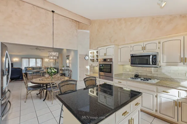a kitchen with appliances cabinets and chairs