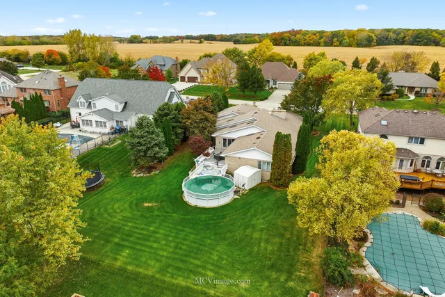 an aerial view of a house with garden space and a lake view