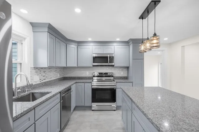 a kitchen with a sink stove and microwave