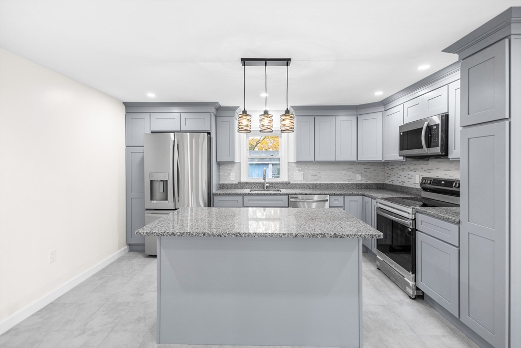 25 Lakeview Street Blackstone, MA 01504 - Photo 4 of 26 a large kitchen with granite countertop a stove and a sink