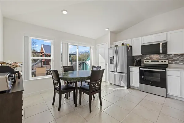 a view of a dining room with furniture and a kitchen