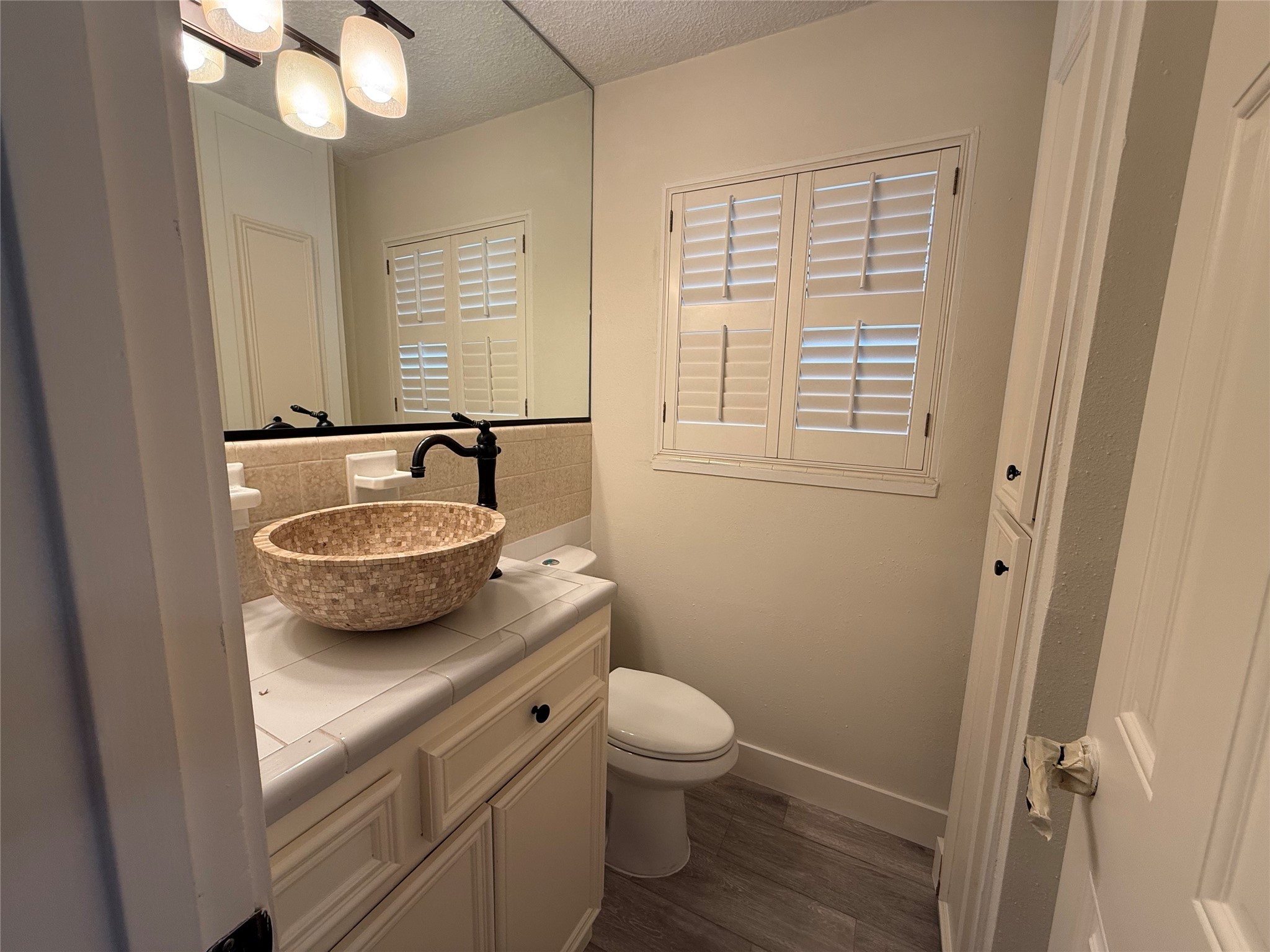 822 Hidden Valley Drive Houston, TX 77088 - Photo 30 of 48 a bathroom with a granite countertop sink toilet a mirror and a tub