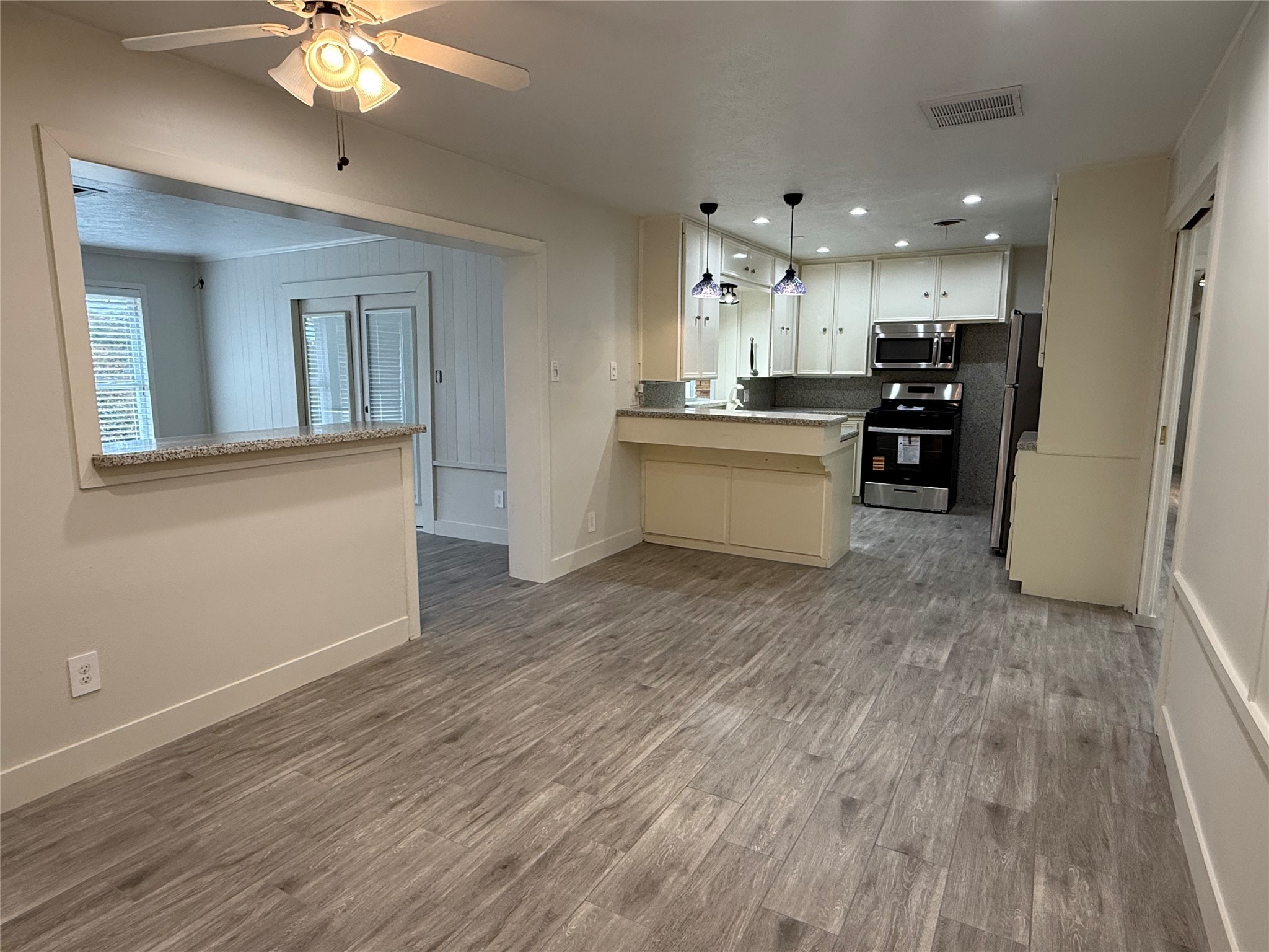 822 Hidden Valley Drive Houston, TX 77088 - Photo 9 of 48 a large kitchen with kitchen island white cabinets and stainless steel appliances