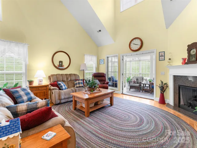 a living room with furniture a clock on wall and a window