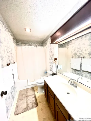 a bathroom with a double vanity sink toilet mirror and bathtub
