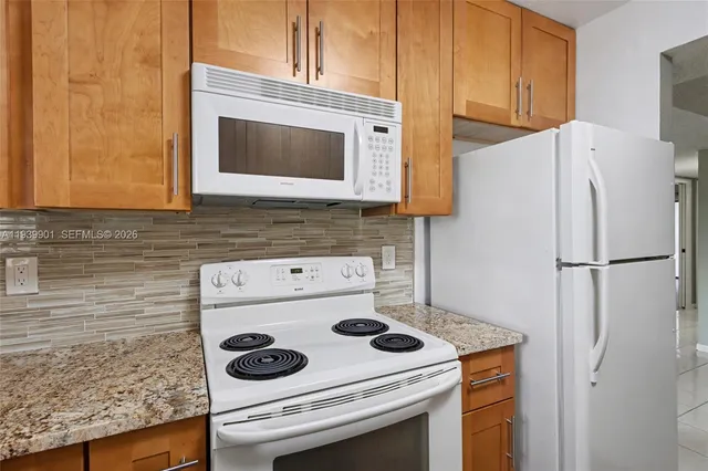 a kitchen with a sink a refrigerator and cabinets