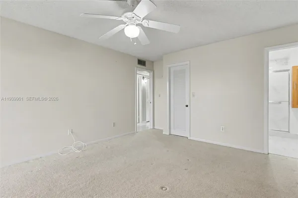 an empty room with windows and ceiling fan