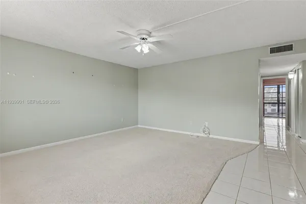 an empty room with a ceiling fan and a window