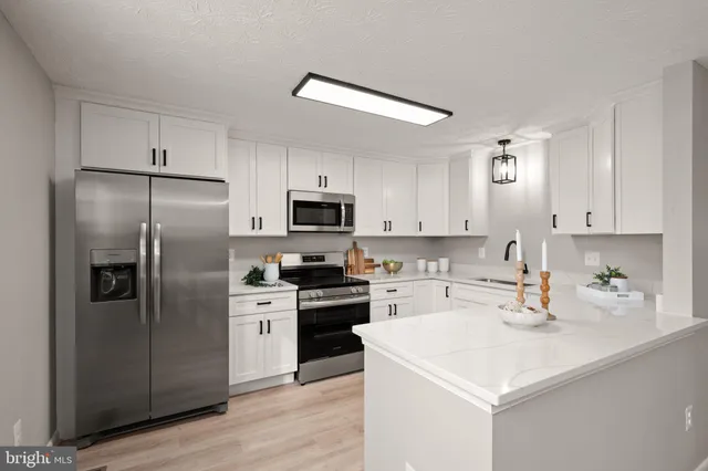 a kitchen with a sink stainless steel appliances and white cabinets