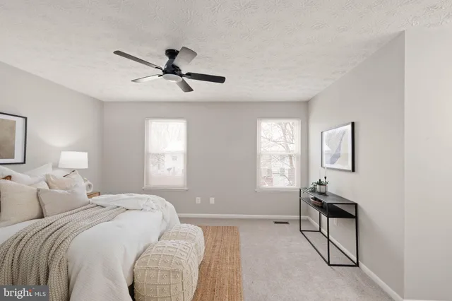 a bedroom with two beds and windows