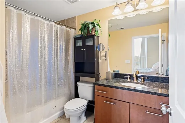 a bathroom with a granite countertop sink toilet and shower