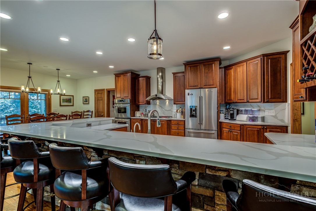 119 Blackberry Lane Boone, NC 28607 - Photo 14 of 41 a kitchen with stainless steel appliances granite countertop a table chairs sink and refrigerator