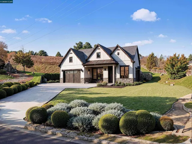 a front view of a house with garden space and patio