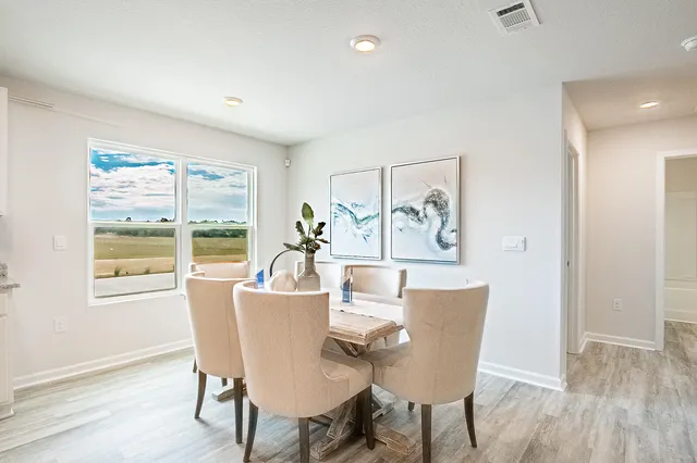 a dining room with furniture a window and wooden floor