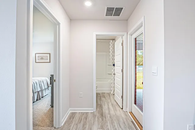 a view of a hallway with wooden floor and closet
