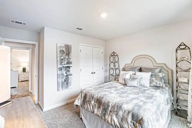 a bedroom with a large bed and a chandelier
