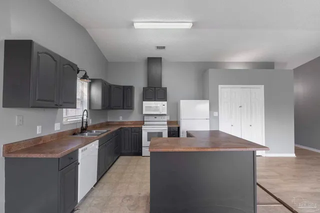 a kitchen with stainless steel appliances granite countertop a sink a stove counter space and cabinets