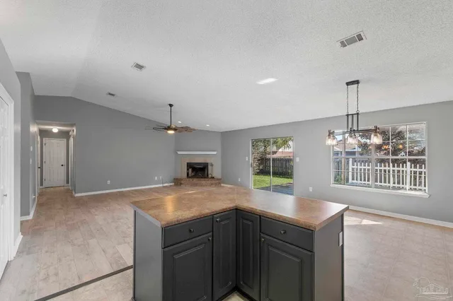 a kitchen with kitchen island a center island a stove and a window